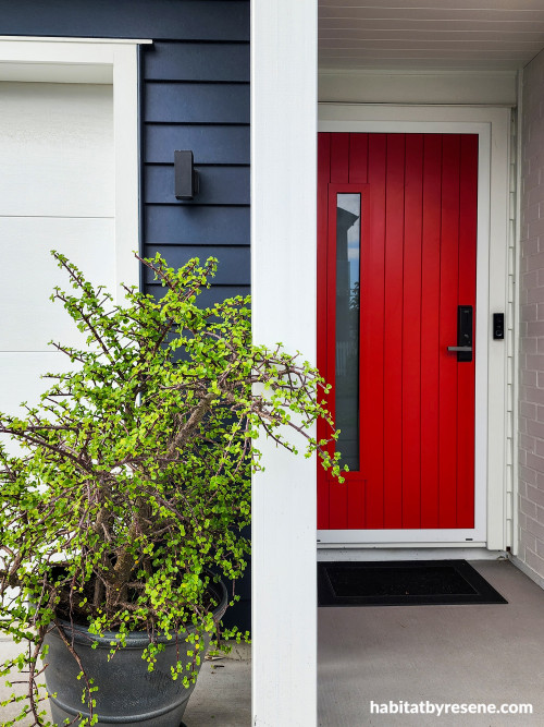 Dark blue house exterior with bright red front door