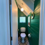 Toilet featuring dark green walls