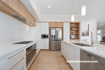 Neutral and timber kitchen featuring cabinets painted in Resene Double Alabaster and walls in Resene Quarter Sandspit Brown
