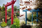 Japanese-inspired garden featuring painted arch 