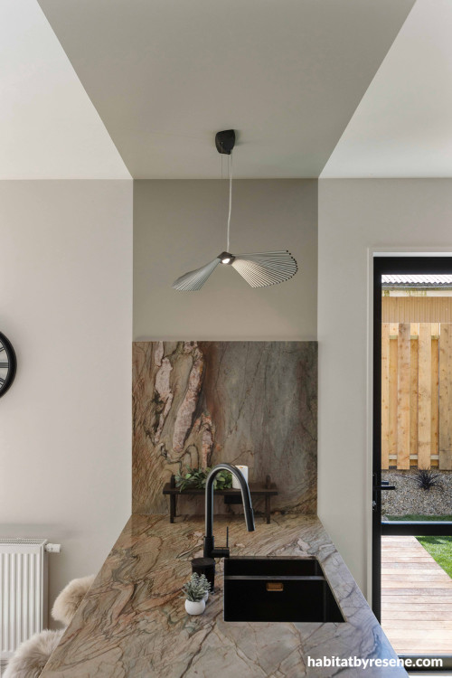 Kitchen with marble benchtop and painted wall feature